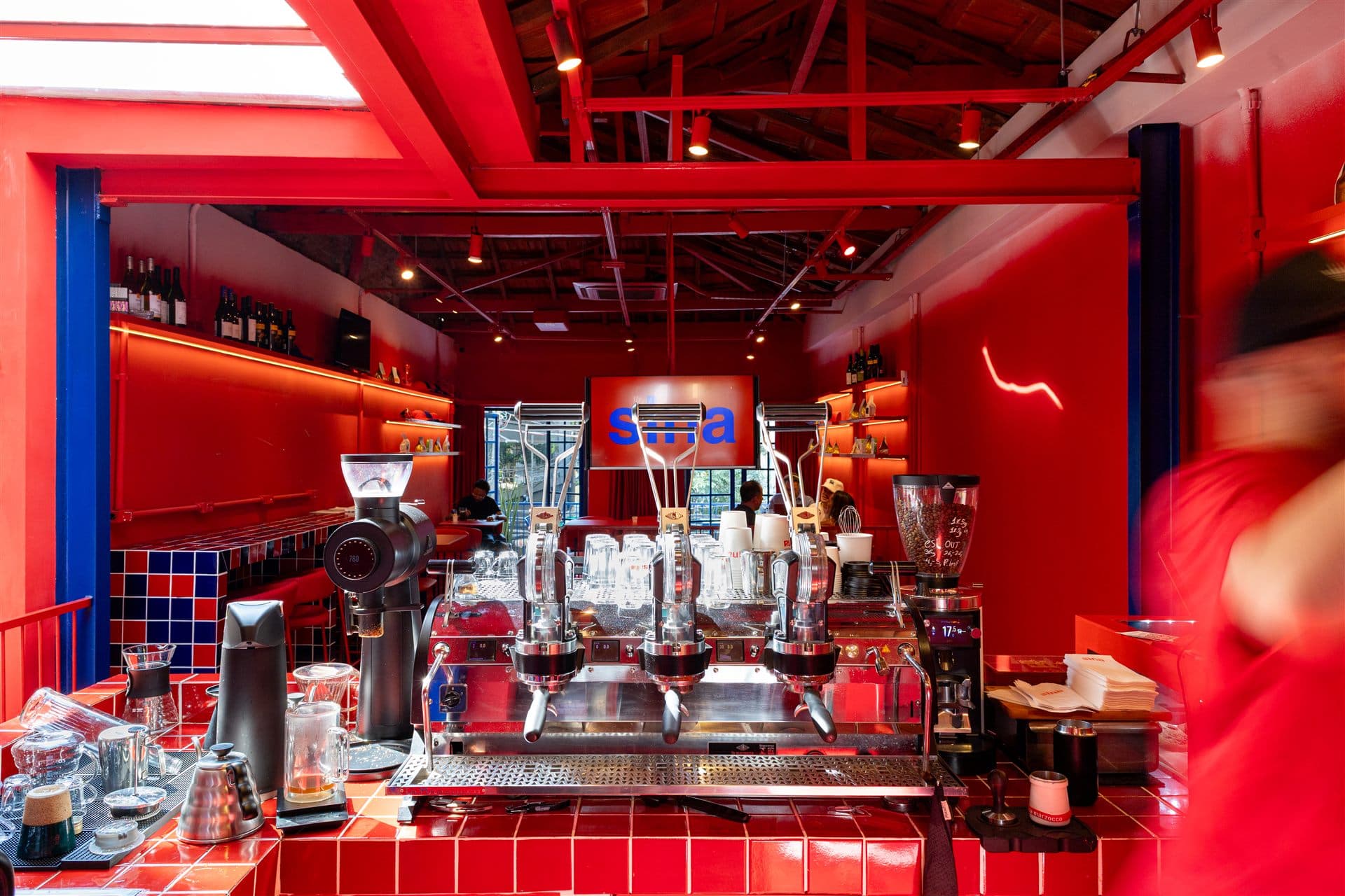 Sina DJ booth: blue disc sign over a checkered counter in a red room full of bicycles.